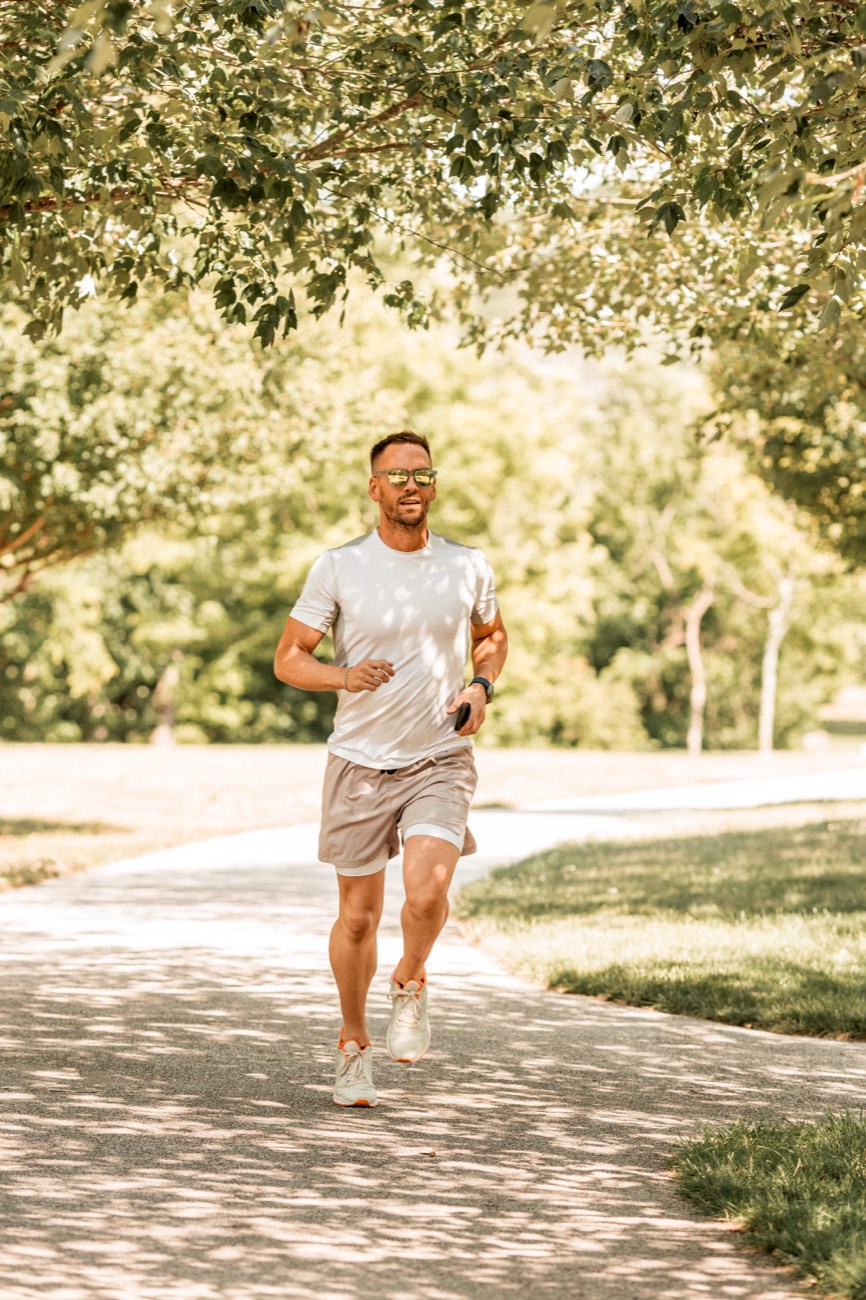 David running on a tree-shaded path in bright morning light.